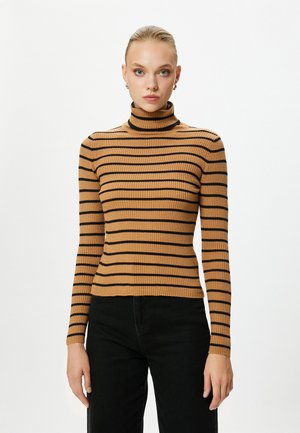 Brązowy sweter z prążkowanym golfem w czarne poziome paski. Dopasowany krój, długie rękawy i jednolity kolor z tyłu, zestawiony z czarnymi spodniami.