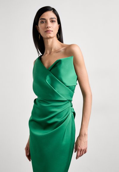 Green satin dress with a one-shoulder design, featuring draped fabric and a twisted knot detail at the waist. Smooth texture and fitted silhouette.