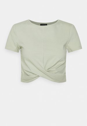 Kortærmet, lysegrøn cropped t-shirt lavet af blødt stof med en snoet detalje foran, rund halsudskæring og en ren afslutning ved kanten.