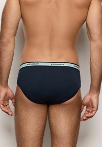 Calzini da uomo blu navy realizzati in materiale elasticizzato, con un cinturino azzurro chiaro recante il nome del marchio "yamamay" in testo ripetuto.