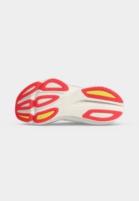 Σόλα παπουτσιού τρεξίματος Saucony με λευκή βάση, κόκκινες και κίτρινες λαστιχένιες επιφάνειες πρόσφυσης και υφασμένο σχέδιο πέλματος.