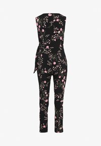 Floral jumpsuit with a black base, featuring pink flowers and green leaves. Sleeveless design with a fitted waist and tapered legs.