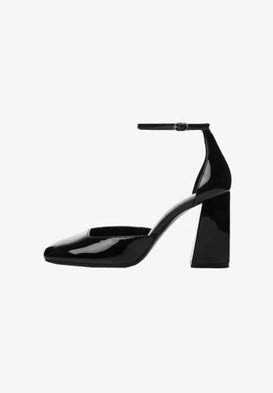 Schwarze Lackleder-Schuhe mit Blockabsatz, Knöchelriemen, quadratischer Zehenpartie und glänzender Oberfläche. Der Absatz ist breit und stabil.