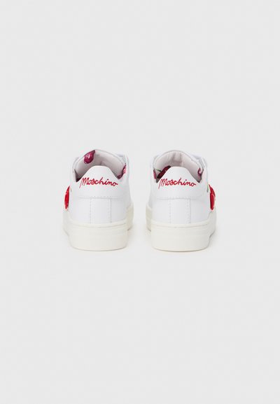 Paire de baskets blanches avec broderie rouge "Moschino" sur les languettes de talon et motifs de cerises sur la doublure intérieure, vues de dos.