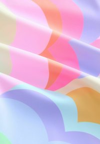 Tissu multicolore à la texture lisse, présentant des formes de cœur superposées dans des teintes de rose, lavande, pêche et bleu clair.