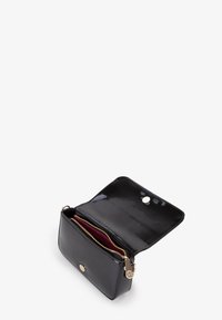 Borsa a tracolla in pelle verniciata nera con chiusura a bottone dorato, tasca interna con zip e due scomparti foderati in colori a contrasto.