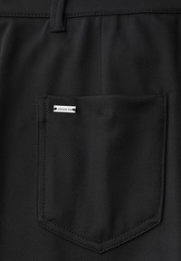 Pantaloni neri con un tessuto texturizzato, dotati di una tasca posteriore rettangolare e di un piccolo etichetta bianca con la scritta "street one".