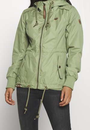 Hellgrüne Jacke mit Reißverschluss, Kapuze, Taillen-Kordelzug, gerippten Bündchen und Seitentaschen. Mit einem Logo-Patch am linken Arm.