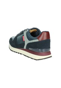 Sneaker blu navy in suede e pelle sintetica, con accenti grigi e un tallone bordeaux. Presenta una robusta intersuola bianca e una suola nera testurizzata.