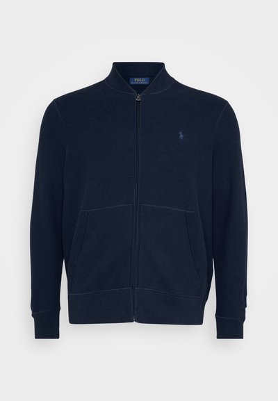 Navy blue zip-up jacket made of textured fabric, featuring a stand collar, two front pockets, and a small logo embroidered on the chest.