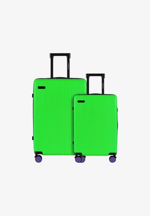 Grünes Hartschalen-Koffer-Set, bestehend aus einem großen und einem kleinen Koffer. Mit vertikalen Rillen, schwarzen Griffen und lila Rollen. Glatte Textur.