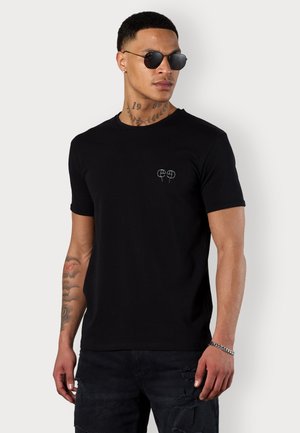 Schwarzes Baumwoll-T-Shirt mit Rundhalsausschnitt, kurzen Ärmeln und einem kleinen bestickten Design auf der linken Brust. Verfügt über eine lockere Passform.