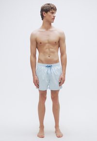 Ανοιχτό μπλε μαγιό σορτς με ελαστική μέση και κορδόνι, κατασκευασμένο από λείο, ελαφρύ ύφασμα. Μήκος μέχρι το γόνατο.