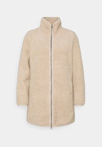 Beżowa polarowa kurtka z wysokim kołnierzem, pełnym zamkiem z przodu i długimi rękawami. Teksturowany materiał o miękkim, ciepłym wyglądzie.