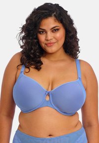 Langaton rintaliivi vaaleansinisestä kankaasta, jossa on kupin yksityiskohtia, pieniä nauhahäntiä keskellä ja säädettävät olkahihnat tukevan istuvuuden varmistamiseksi.