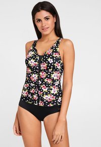 Tankini noir à motifs floraux roses et verts, avec un devant volant et des bretelles ajustables, associé à un bas noir uni.