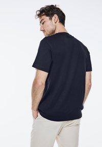 Námořnické bavlněné tričko s krátkým rukávem, kulatým výstřihem a volným střihem. Hladká textura s jednoduchým designem.