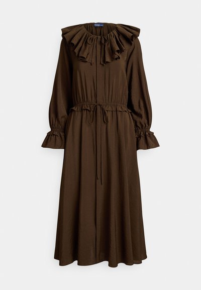 Ruda ilgomis rankovėmis suknelė su raukšlėtu apykaklės kraštu, surištu liemeniu ir platėjančia sijono dalimi. Tekstūruota medžiaga ir susmulkinti rankogalviai su raišteliu.