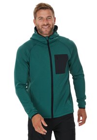 Giacca verde con cappuccio e cerniera completa, presenta una tasca sul petto con cerniera nera, tessuto texturizzato e polsini aderenti.