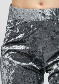 Leggings in velluto grigio con una finitura lucida e texturizzata e una cintura elastica larga. Presentano un aspetto di tessuto liscio e morbido.