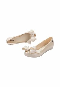 Ballet flat beige realizzate in plastica liscia con un grande fiocco decorativo sulla punta e un design con apertura. Presentano un leggero tacco a cuneo.