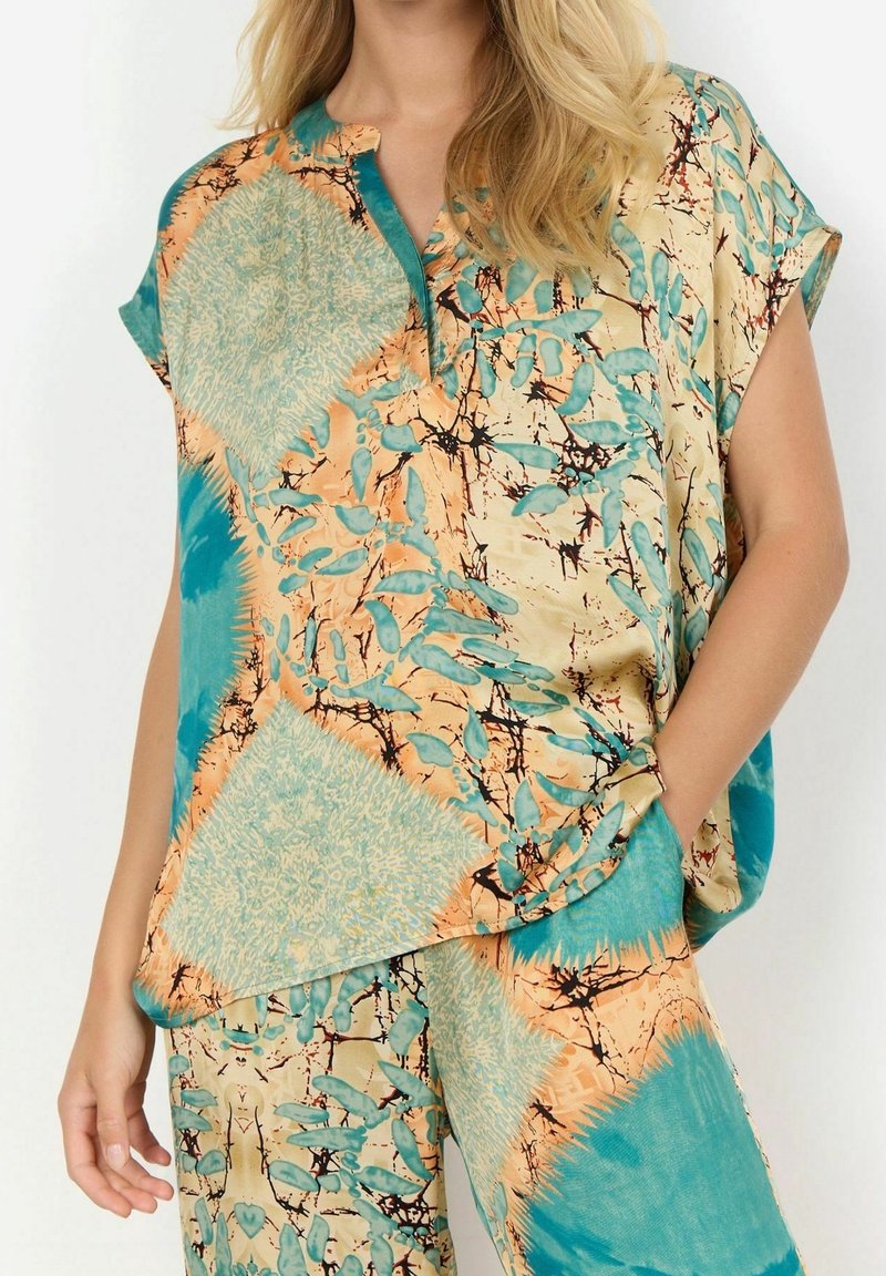Kurzärmliges, lässig geschnittenes Oberteil mit einem mehrfarbigen, floralem Muster in Türkis, Orange und Beige sowie einem Knopfkragen für zusätzliche Details.