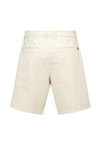 Shorts in cotone beige con vita elastica, due tasche posteriori e un'etichetta con logo sul lato destro. Texture liscia con un design casual.