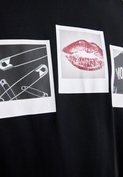 T-shirt noir avec trois imprimés graphiques carrés : épingles de sûreté, lèvres rouges et une image textuelle monochrome. Texture lisse, design décontracté.