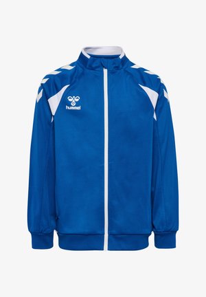 Blue zip-up sports jacket with white chevron patterns on shoulders, white zipper, and "hummel" logo on left chest.