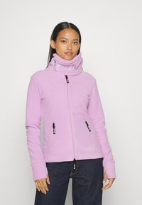 Helllila Fleecejacke mit hohem Kragen, Reißverschluss vorne und zwei Seitentaschen mit schwarzen Zuglaschen; glatte Textur.