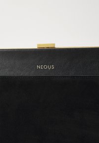 Pochette en cuir noir avec une partie supérieure lisse et une partie inférieure en daim. Dotée d'un fermoir doré et du logo 'NEOUS' estampé à l'avant.