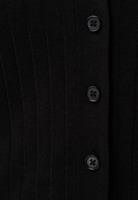 Zwarte geribbelde gebreide cardigan met vier ronde knopen, die een gemêleerd ontwerp met verticale strepen en een getailleerde vorm accentueert.