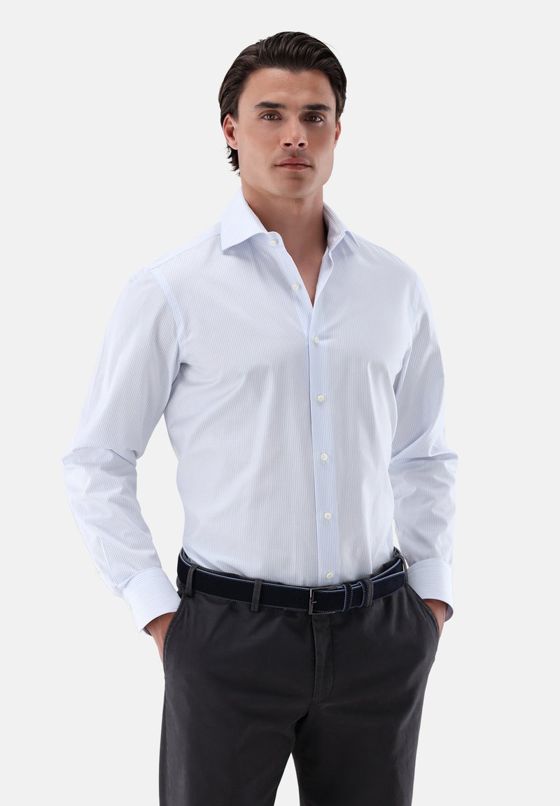 Camicia button-up a righe blu chiaro con colletto, maniche lunghe e bottoni bianchi, abbinata a pantaloni scuri e una cintura coordinata.