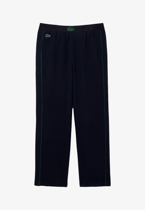 Marina atletiska byxor med gröna sido-ränder, elastisk midja och Lacoste-logotyp. Tillverkade av strukturväv, designade för komfort och rörelse.