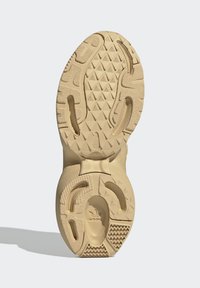 Bežinė sportinių batelių pado dalis su geometrinėmis struktūromis, tekstūruotais skyriumi ir apvaliais išpjovimais. Patvari gumos medžiaga su įvairiais protektoriaus raštais.