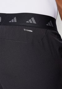 Schwarze Sportshorts aus strukturiertem Material mit CLIMACOOL-Branding und einem schwarzen Bund, der ein dezentes adidas-Logo-Muster aufweist.