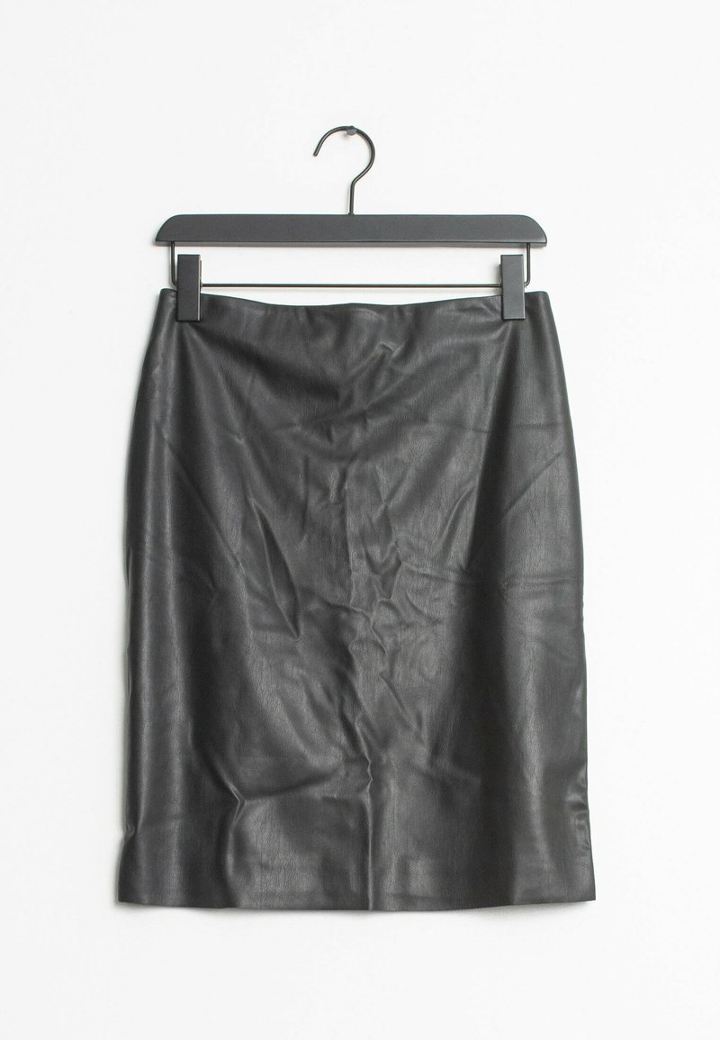 Jupe en cuir noire longueur genoux suspendue sur un cintre noir sur fond blanc.