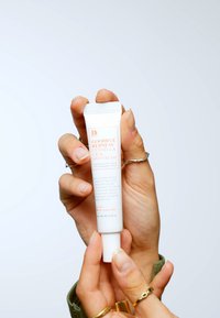 Tubo blanco con tapa de rosca, que presenta "Crema de Puntos Centella Cica Goodbye Redness" en texto naranja. Tamaño de 0,5 oz, textura suave.