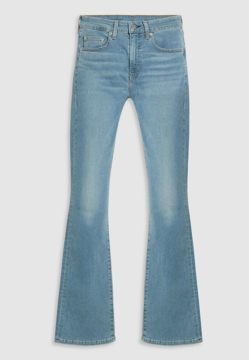 Vaqueros de denim de un azul claro, acampanados y de talle alto, con bolsillos delanteros y un ligero desgaste; textura suave y dobladillo limpio.