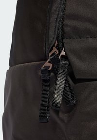 Zaino nero con un'esterno texturizzato, chiusura con zip dotata di doppie linguette e spallacci regolabili realizzati in materiale intrecciato.