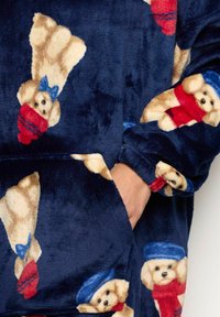 Fleece albastru, cu un model repetat de ursuleți de pluș în bej, purtând accesorii roșii și albastre. Include o buzunar frontal și o textură moale.