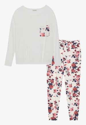 Λευκή μπλούζα με μακριά μανίκια και λουλουδάτη τσέπη, συνδυασμένη με παντελόνια πυζάμας με λουλουδάτο μοτίβο σε κρέμα, κόκκινες και ναυτικές αποχρώσεις. Μαλακό και ελαφρύ ύφασμα.