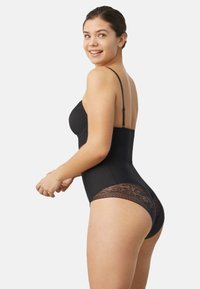 Body de control negro con tirantes finos ajustables y detalles de encaje en las caderas. Textura suave con un diseño ajustado.