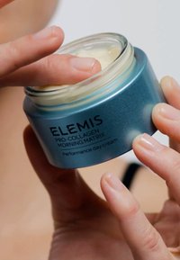 Vasetto di vetro blu con finitura metallica, etichettato "ELEMIS Pro-Collagen Morning Matrix", contenente un prodotto cremoso di colore chiaro.