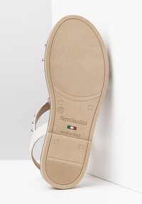 Sandalo bianco con una suola piatta e testurizzata beige. Presenta dettagli in metallo argentato e un design semplice. Contrassegnato con la taglia 37 e prodotto in Italia.