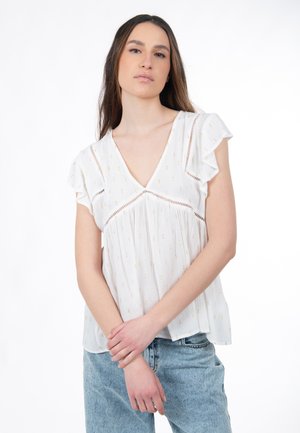 Blusa bianca con scollo a V, maniche svolazzanti e motivi dorati, realizzata in tessuto leggero con una finitura testurizzata.