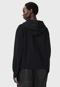 Czarna bluza z kapturem o luźnym kroju, z prążkowanymi mankietami i gładką fakturą. Posiada kieszeń typu kangur i minimalistyczny design.