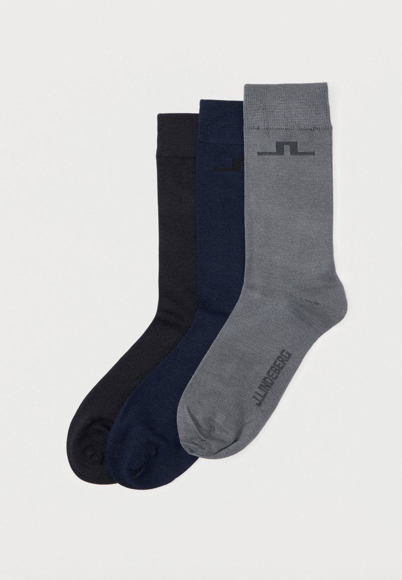 Trois paires de chaussettes unies à tige moyenne empilées, couleurs de gauche à droite : noir, bleu marine et gris avec un marquage subtil.
