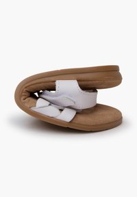 Witte sandalen met een zachte suede binnenzool, voorzien van een verstelbaar bandje en een flexibele, lichtbruine rubberen zool. Eenvoudig ontwerp met minimale hardware.
