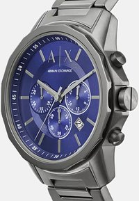 Hõbedane roostevabast terasest kell sinise kellaga. Omadusteks on kolm alamkella, hõbedased markeerijad ja kuupäeva näitamine kell 6.